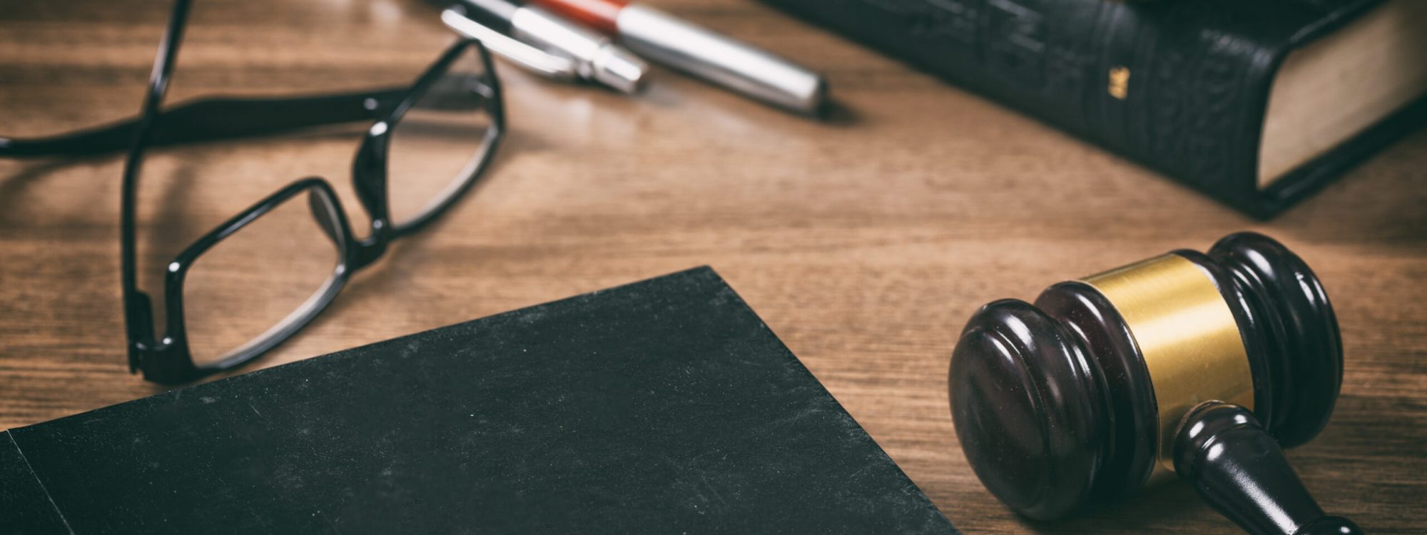 Court room. Law or auction gavel  and a hard cover book on a wooden office desk background. Closeup view, space for text